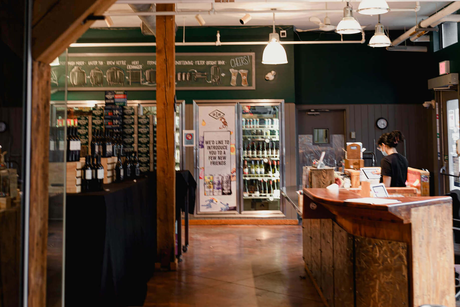 inside the retail store with beer fridge and stuff, and the cashier on the right side