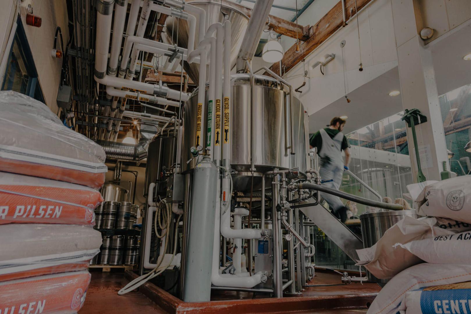 Person in brewery process, with sacks of barley