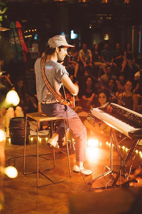 man playing guitar in a scenery with people