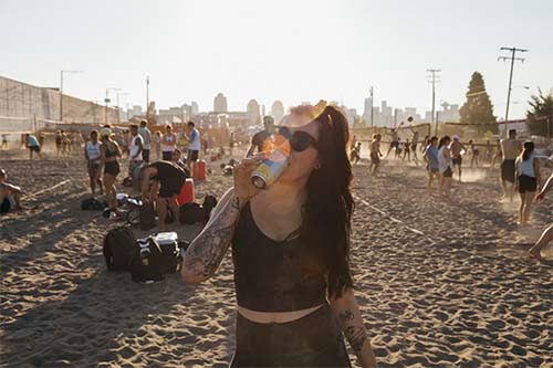 girl drink a granville beer in a beach