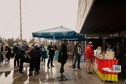 persons bellow umbrellas front a granville stand