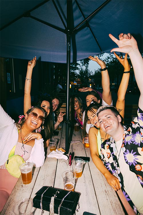 persons posing for photo with the arms in the air