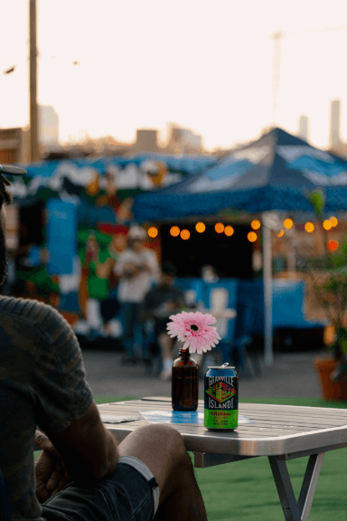 out-of-focus photo of a table with a granville beer next to a vase